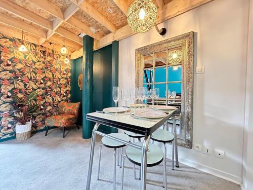 une salle à manger avec une table, des chaises et un miroir dans l'établissement Delacroix magnifique T2 avec parking au centre, à Reims