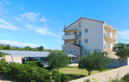 ein großes weißes Gebäude mit Parkplatz in der Unterkunft Bed & Breakfast Jugo in Novalja