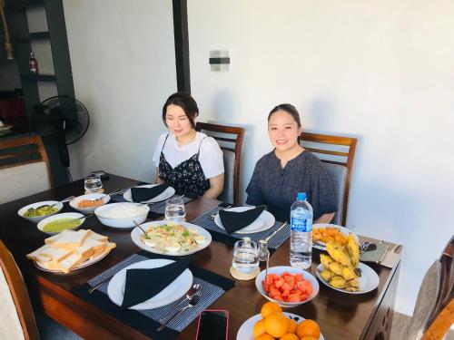 two women sitting at a table with food at Villa Navodi in Negombo