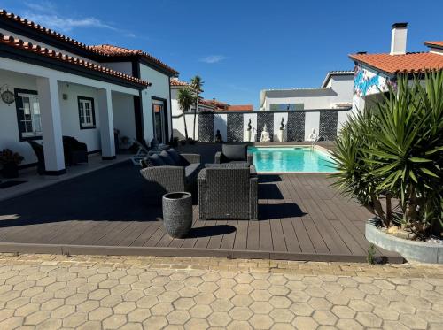 a patio with chairs and a pool in a house at Spacious quiet charming villa with private pool and close to Lisbon in Monte de Lucas