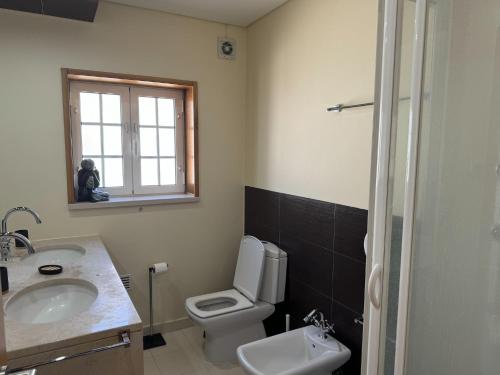 a bathroom with a white toilet and a sink at Spacious quiet charming villa with private pool and close to Lisbon in Monte de Lucas