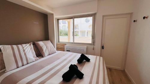 a bedroom with a large bed with two black objects on it at La Cachette in La Grande-Motte