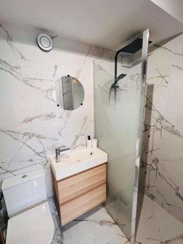 une salle de bain avec un lavabo et une douche dans l'établissement La Cachette, à La Grande Motte
