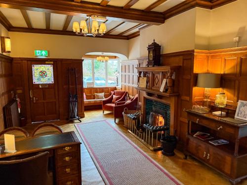 a living room with a fireplace and a couch at Lindeth Fell Country House in Bowness-on-Windermere