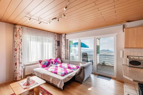 a living room with a bed and a large window at Ferienwohnung mit Aussicht in Notscheid