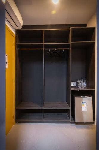 a closet with glass shelves and a refrigerator at Altitude Loft Hotel in Maracaibo