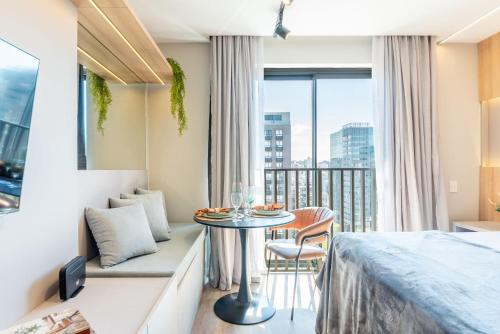 a room with a bed and a table and a balcony at GO24 by LikeHome in Auxiliadora