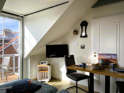 a room with a desk and a table with a chair at Huus Waterkant 07 auf Amrum in Wittdün