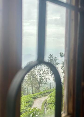 a view of a dirt road through a window at ABC Guest Inn & Restaurant in Haputale