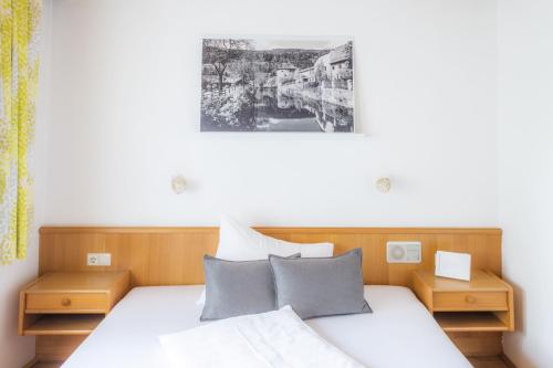 a bedroom with a white bed with two night stands at Der Torwirt Radstadt in Radstadt