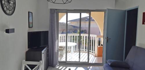 d'un salon avec une porte coulissante en verre s'ouvrant sur un balcon. dans l'établissement T2 air-conditioned Port Fréjus with parking, à Fréjus