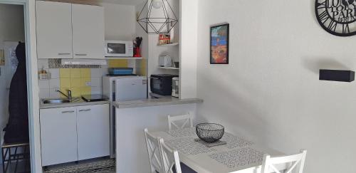 une petite cuisine avec une table et des chaises dans une pièce dans l'établissement T2 air-conditioned Port Fréjus with parking, à Fréjus