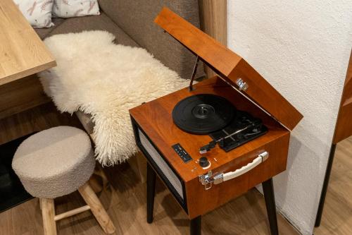 a table with a phone on it next to a chair at Bergvilla Vivaldi - Happy Mountain Vibes in Mühlbach am Hochkönig