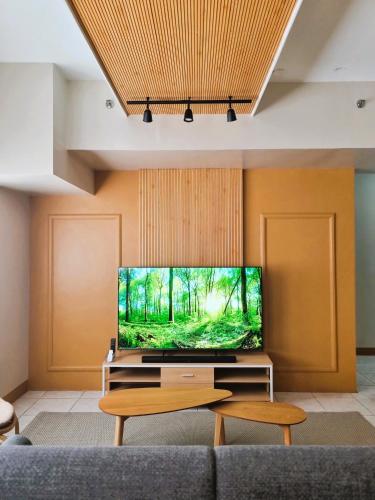 a living room with a flat screen tv on a wall at Newly Furnished Condominium in the Heart of Quezon City near Top Philippine Hospitals in Manila