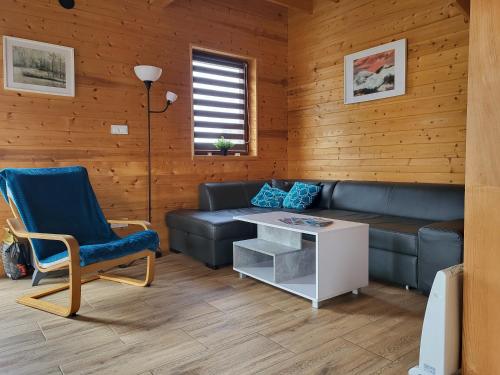 a living room with a couch and a table at Słowińskie Widoki domki Flora, Fauna, noclegi Smołdziński Las in Smołdziński Las
