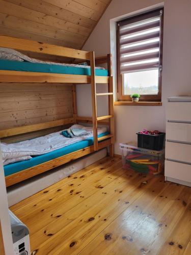 a bedroom with two bunk beds and a window at Słowińskie Widoki domki Flora, Fauna, noclegi Smołdziński Las in Smołdziński Las