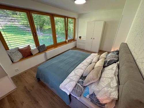 a large bed in a room with a large window at Apartment House - Oparno 16 in Velemín