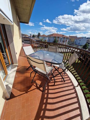 a patio with a table and chairs on a balcony at Giulietta Apartment Cuneo in Cuneo