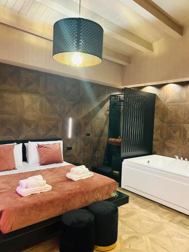 a bedroom with a bed and a tub and a sink at Spera Luxury Palermo & SPA in Palermo