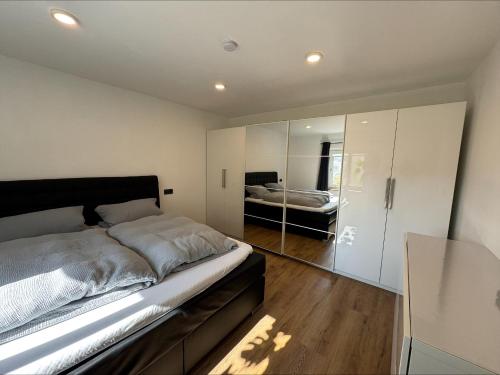 a bedroom with a large bed and a mirror at Ferienwohnung Am Biohof in Mengkofen