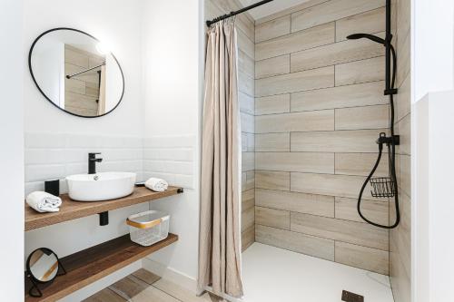 a bathroom with a shower with a sink and a mirror at Les iles, T2 vue mer in Rivedoux-Plage