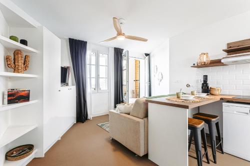 a kitchen and living room with a couch and a table at La Terrasse, studio vue mer in Rivedoux-Plage