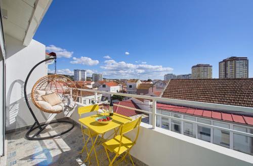 a balcony with a yellow table and chairs on a roof at Ocean & Sun Terrace w AC, by TimeCooler in Costa da Caparica