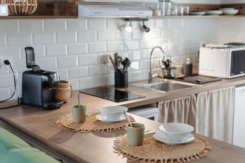 a kitchen counter with two cups and a sink at La Terrasse, studio vue mer in Rivedoux-Plage
