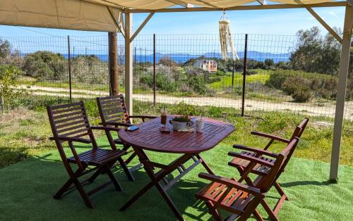 a wooden table and chairs under an umbrella at Vanna's Holiday House in Ierissos
