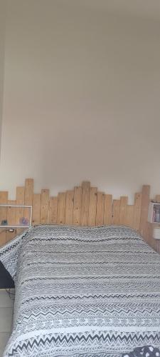 拉贝尔讷里昂雷茨Appartement vue mer的卧室里有一张带木质床头板的床
