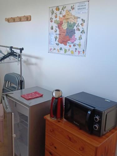 - un four micro-ondes installé au-dessus d'une commode en bois dans l'établissement Chambre au calme - Université, à Dijon