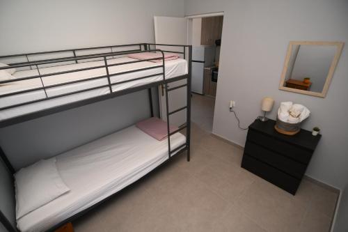 a room with two bunk beds and a mirror at Rose Garden Apartments in Mitikas