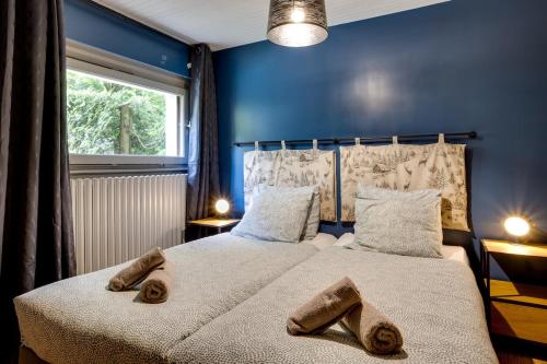 - une chambre bleue avec 2 lits et des serviettes dans l'établissement Roches Blanches - Super location & 