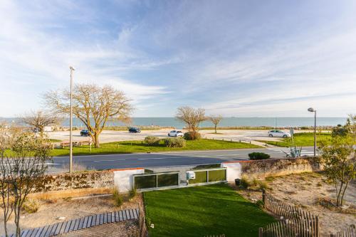 a view of a street with a road and the ocean at Le Phare, Studio vue mer in Rivedoux-Plage