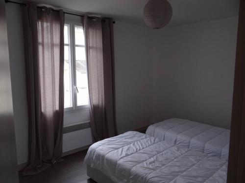 - une chambre avec un lit en face d'une fenêtre dans l'établissement Charmante maison au cœur du village, à Saint-Nicolas-de-Bourgueil