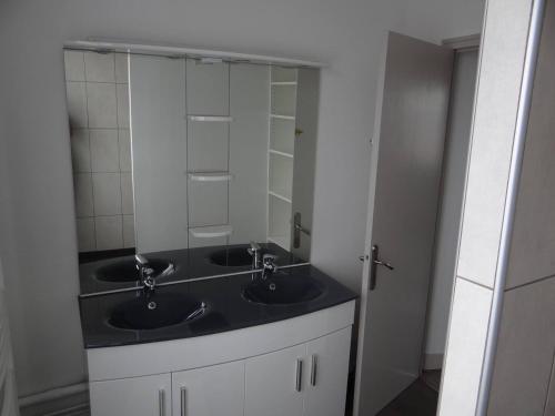 une salle de bain avec deux lavabos et un grand miroir dans l'établissement Charmante maison au cœur du village, à Saint-Nicolas-de-Bourgueil