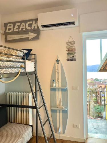 a bedroom with a bunk bed and a surfboard on the wall at Happy Days On The Lake! in Viverone