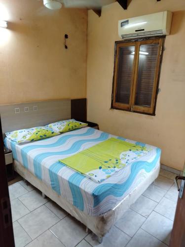 a bed sitting in a bedroom with a window at Habitación en casa zona Asunción in Asunción