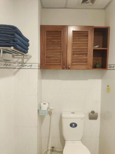 a bathroom with a toilet and wooden cabinets at N's house in Phan Thiet