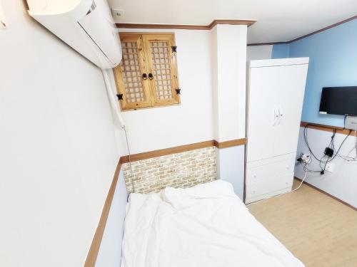 a small room with a bed and a television at Sweet House in Seoul