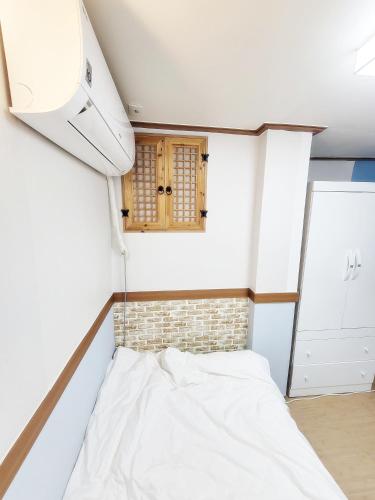 a small room with a bed and a window at Sweet House in Seoul