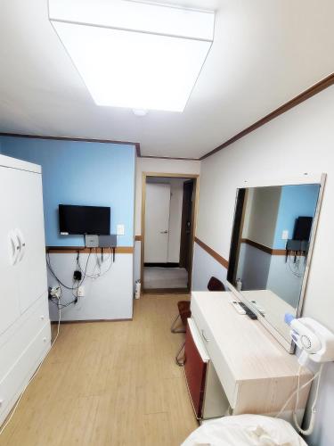 a hospital room with a desk and a tv at Sweet House in Seoul