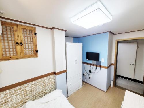 a room with a bed and a tv on the wall at Sweet House in Seoul