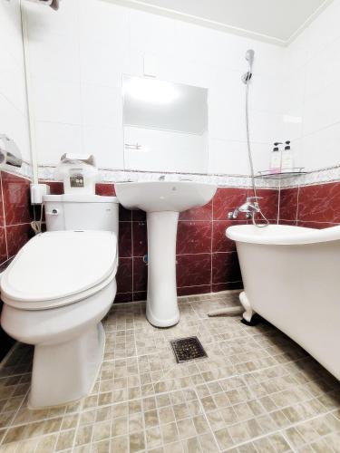 a bathroom with a toilet and a sink and a tub at Sweet House in Seoul
