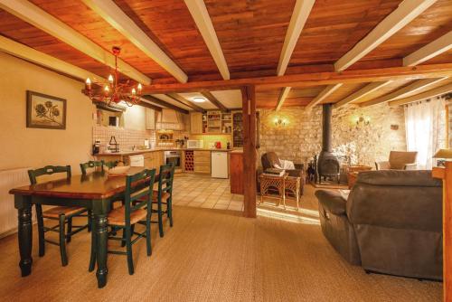 a kitchen and living room with a table and chairs at La Garenne in Carnac-Rouffiac
