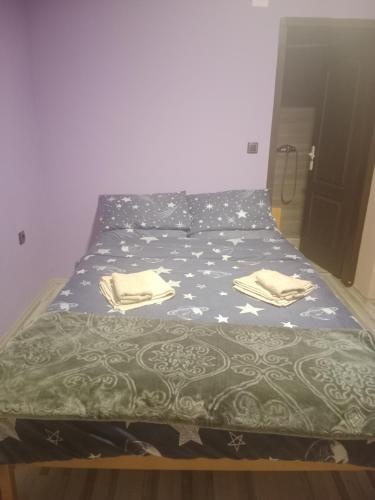 a bedroom with a bed with a green and white comforter at Južna priča Miki in Ćuprija