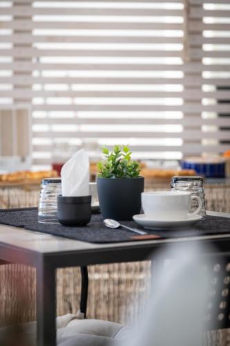 a table with dishes and a plant on it at Dea's Rooms in Noto