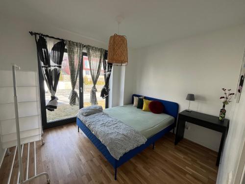 a bedroom with a blue bed and a window at Guest room with private bathroom in Åkersberga
