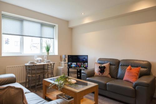 a living room with a couch and a table at Pinfold Court Apartments in Knowsley