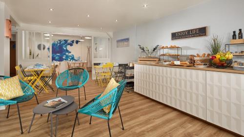 een keuken en eetkamer met stoelen en een aanrecht bij Hotel Résidence Paris Asnières in Asnières-sur-Seine